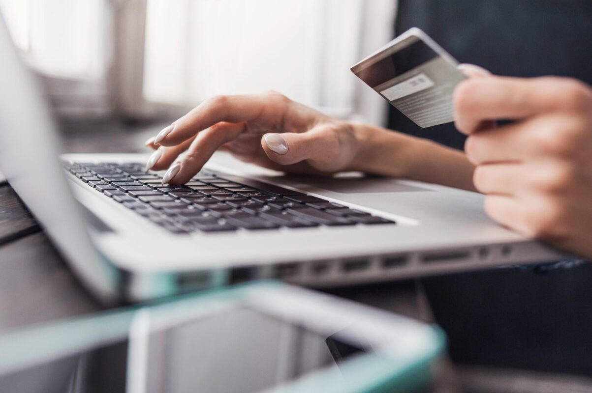 Hand Holding Credit Card And Using Laptop. Businesswoman Or Entrepreneur